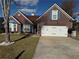 Charming brick home featuring a two-car garage, manicured lawn, and vibrant blue window shutters at 8827 Lake Rd, Union City, GA 30291