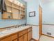 Bright bathroom featuring double sinks, wooden cabinets and an open shelf for storage at 5 Ridgewood Cir, Mcdonough, GA 30252