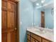 Bright bathroom featuring a wood door, light blue walls, a large mirror and vanity with wood drawers at 5 Ridgewood Cir, Mcdonough, GA 30252