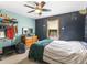 Cozy bedroom with modern ceiling fan, an accent wall, a storage rack, and a large window at 5 Ridgewood Cir, Mcdonough, GA 30252