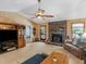 Spacious living room featuring a cozy fireplace, ceiling fan and neutral carpeting at 5 Ridgewood Cir, Mcdonough, GA 30252