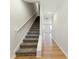 Hallway with carpeted stairs and railing leading to the second floor, adjacent to hardwood floors at 5634 Union Pointe Dr, Union City, GA 30291