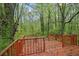 View of a wooden back deck overlooking a lush green forest at 1513 Spruce Ridge Way, Stone Mountain, GA 30083