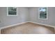 This naturally-lit bedroom features two windows and attractive wood-look flooring at 1513 Spruce Ridge Way, Stone Mountain, GA 30083