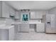 Well-lit kitchen with stainless steel refrigerator, stylish grey cabinets, and gray tiled flooring at 1513 Spruce Ridge Way, Stone Mountain, GA 30083