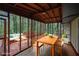 Screened-in porch featuring a rustic dining table, neutral furniture, and an airy ambiance with views of surrounding trees at 1513 Spruce Ridge Way, Stone Mountain, GA 30083