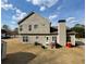 Rear exterior view of the house featuring a patio and spacious backyard with trees at 1763 Emerald Dr, Jonesboro, GA 30236