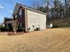 View of a two story home on a large lot with trees in the background and shed in the yard at 1763 Emerald Dr, Jonesboro, GA 30236