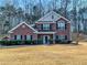 Charming brick two-story home with manicured landscaping and black shutters against a background of mature trees at 1763 Emerald Dr, Jonesboro, GA 30236
