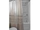 Close-up of shower-tub combination with modern fixtures and neutral shower curtain at 2650 Longacre Park Way, Lawrenceville, GA 30044