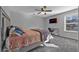 Well-lit bedroom features a ceiling fan, mounted television, desk area, and cozy bedding for ultimate comfort at 2650 Longacre Park Way, Lawrenceville, GA 30044