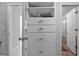 Custom closet featuring sleek white drawers, shelves, and access to additional storage spaces at 2650 Longacre Park Way, Lawrenceville, GA 30044