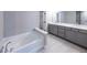 Elegant bathroom featuring double sinks, gray cabinets, and a relaxing soaking tub at 3739 Silvery Way, Powder Springs, GA 30127