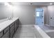 Bright bathroom featuring a long vanity with double sinks, tile flooring and soaking tub at 3739 Silvery Way, Powder Springs, GA 30127