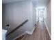 Bright hallway featuring light wood flooring and a modern wall sconce near the staircase at 3739 Silvery Way, Powder Springs, GA 30127