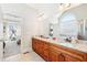 Bright bathroom featuring double vanity with granite countertop, natural light, and entrance to the bedroom at 110 Canyon Ridge Trl, Canton, GA 30114