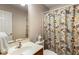 Well-lit bathroom featuring a floral shower curtain, neutral wall color and updated sink at 172 Knightwood Point, Acworth, GA 30101