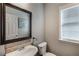 Clean bathroom with tile accents, a large mirror, sink, toilet, and a window for natural light at 172 Knightwood Point, Acworth, GA 30101