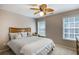 Inviting bedroom showcasing a ceiling fan, two windows with blinds, and a comfortable bed at 172 Knightwood Point, Acworth, GA 30101