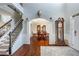Inviting entryway with a staircase and an archway leading to a dining room, next to an antique clock at 172 Knightwood Point, Acworth, GA 30101