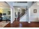 Elegant foyer with hardwood floors, staircase, and arched doorways leading to rooms with keyboard and piano at 172 Knightwood Point, Acworth, GA 30101