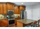 Modern kitchen with stainless steel appliances, granite counters, wooden cabinets, and a peninsula with bar stools at 172 Knightwood Point, Acworth, GA 30101