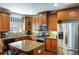 Modern kitchen with stainless steel appliances, granite counters, wooden cabinets, and a peninsula with bar stools at 172 Knightwood Point, Acworth, GA 30101
