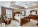Spacious main bedroom with tray ceiling, decorative headboard, and large windows providing ample natural light at 172 Knightwood Point, Acworth, GA 30101