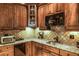 The wet bar boasts wood cabinets, granite counters, tiled backsplash, and stainless-steel appliances at 172 Knightwood Point, Acworth, GA 30101