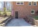 The back entrance has a concrete pad, brick walls, and a brick facade with a black door and an American flag on the wall at 3701 Rainbow Cir, Snellville, GA 30039
