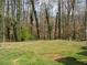 A large backyard with a fence and wooded backdrop, offering privacy and a natural setting at 3701 Rainbow Cir, Snellville, GA 30039