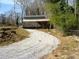 View of the backyard featuring sheds, gravel walkway, trees, and a wire fence at 3701 Rainbow Cir, Snellville, GA 30039