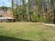 View of the backyard featuring a shed, trees, and a grassy area at 3701 Rainbow Cir, Snellville, GA 30039