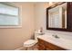 Bathroom with white sink vanity, decorative mirror, and tiled window at 3701 Rainbow Cir, Snellville, GA 30039