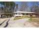Exterior view of home with carport, featuring a paved driveway and tidy landscaping at 3701 Rainbow Cir, Snellville, GA 30039