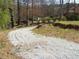View of a gravel driveway leading through a wooded area, showcasing the home's secluded setting at 3701 Rainbow Cir, Snellville, GA 30039