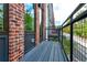 View of a private balcony with brick and metal elements, overlooking greenery at 1239 Chelsea Nw Cir, Atlanta, GA 30318