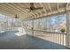 Outdoor deck with ceiling fans and white railing overlooking a beautiful lake view surrounded by trees at 2504 Loch View Sw Ct, Conyers, GA 30094