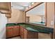 Wet bar with wood cabinets, granite countertop, and a window into the adjacent basement recreation room at 2504 Loch View Sw Ct, Conyers, GA 30094