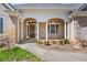 Inviting front porch with brick accents, columns, and decorative glass front door at 2504 Loch View Sw Ct, Conyers, GA 30094
