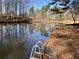 Peaceful lake with dock access and ladder, surrounded by trees, offering a tranquil setting at 2504 Loch View Sw Ct, Conyers, GA 30094