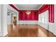 Spacious living room featuring hardwood floors, red accent walls, and classic trim work at 2504 Loch View Sw Ct, Conyers, GA 30094