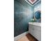 Elegant powder room with custom teal wallpaper and a round mirror above a white vanity at 2504 Loch View Sw Ct, Conyers, GA 30094