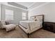 Serene bedroom featuring a stylish bed, chaise lounge, and ample natural light from two windows at 736 Red Wolf Run, Atlanta, GA 30349