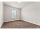 A carpeted bedroom featuring neutral walls and natural light at 736 Red Wolf Run, Atlanta, GA 30349