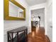 Hallway with hardwood floors leading to a living room and featuring a decorative mirror and console table at 736 Red Wolf Run, Atlanta, GA 30349