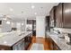 Spacious kitchen featuring dark cabinets, granite countertops, stainless steel appliances, and hardwood floors at 736 Red Wolf Run, Atlanta, GA 30349