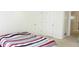 Clean bedroom with carpet, two white doors and a striped bedspread in a neutral color palette at 179 Hunters Crk, Dallas, GA 30157