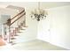 Bright foyer with a staircase featuring wood handrails, white risers, and a chandelier at 179 Hunters Crk, Dallas, GA 30157