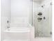 Bright bathroom featuring a tub with marble surround and a glass-enclosed shower with stone floor at 390 17Th Nw St # 5031, Atlanta, GA 30363